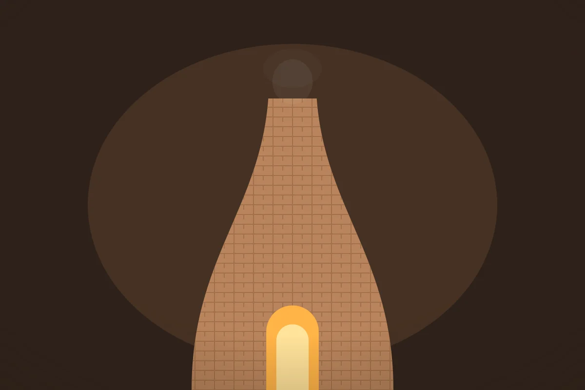 A brick bottle kiln glowing orange from the fire inside.